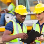 Constructions workers with helmets discussing document