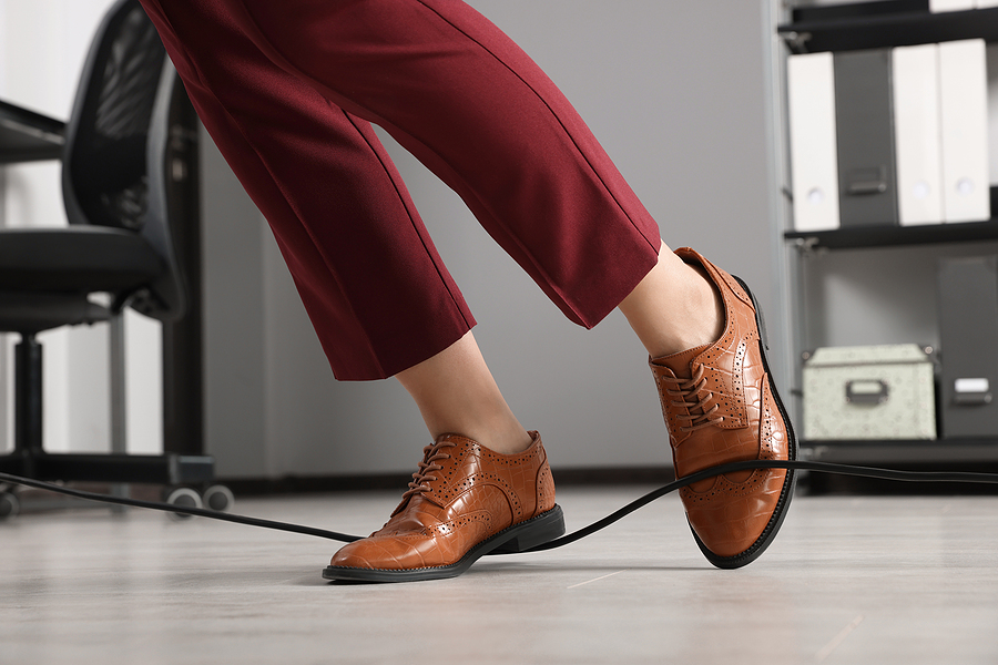 Woman Tripping Over Cable In Office, Closeup